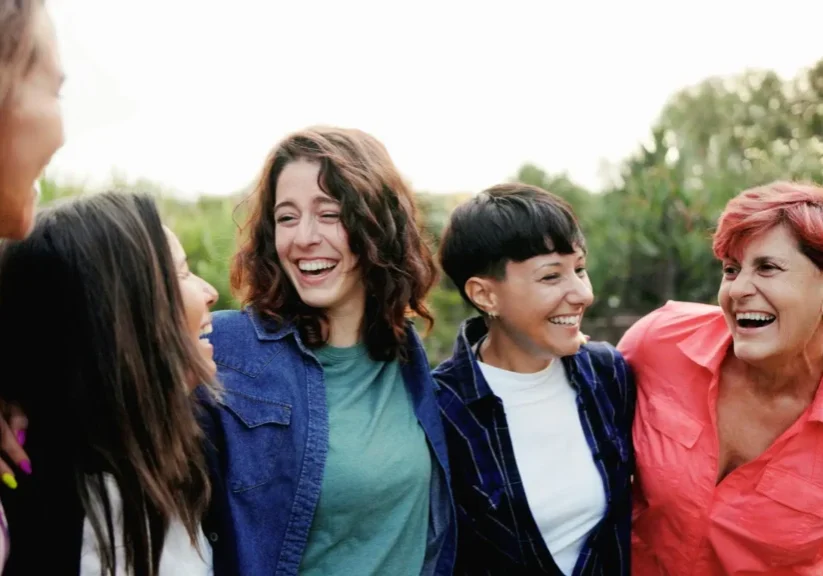 Group of friends laughing outdoors together.