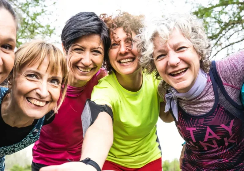 Group of women smiling outdoors together.